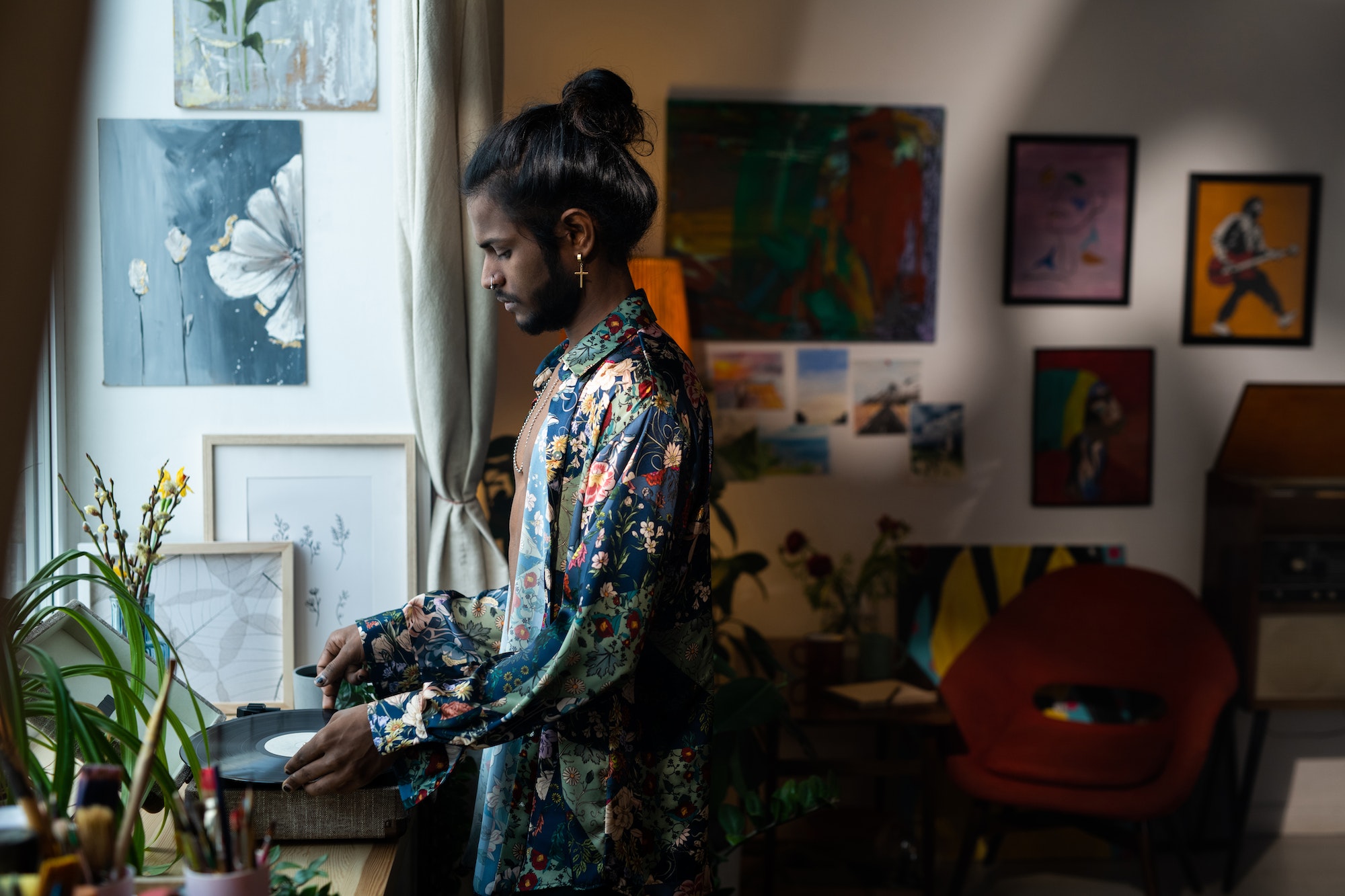 Contemporary young man of Indian ethnicity putting vinyl record in player